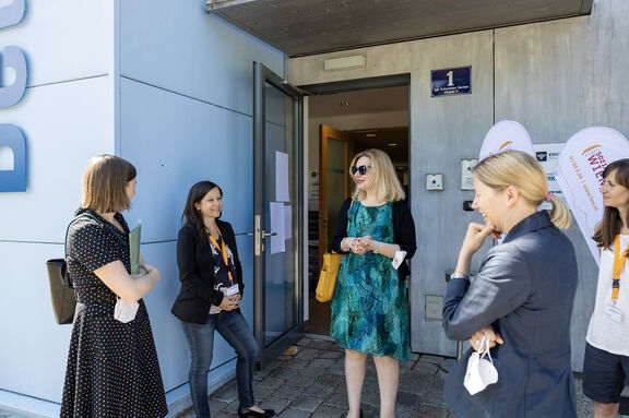 FSW-Geschäftsführerin Anita Bauer mit Mitarbeiter:innen und Gästen vor dem Standort des Betreuten Kontos der Schuldnerberatung Wien