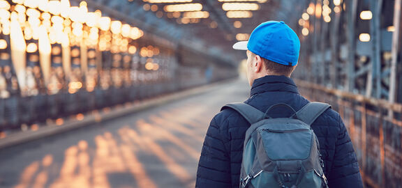 Junger Mann geht auf einer Brücke