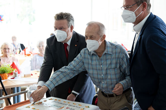 Bürgemerister Michael Ludwig (l.) und Bezirksvorsteher Georg Papai (r.) schnitten die Torte gemeinsam mit einem Tageszentrums-Kunden an. | FSW Bürgemerister Michael Ludwig (l.) und Bezirksvorsteher Georg Papai (r.) schnitten die Torte gemeinsam mit einem Tageszentrums-Kunden an.