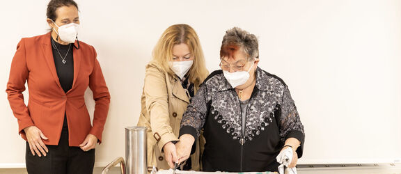 FSW-Geschäftsführerin Anita Bauer und die Geschäftsführerin der FSW-Tageszentren, Bianca Groß, beim Tortenanschnitt mit einer Kundin. | FSW FSW-Geschäftsführerin Anita Bauer und die Geschäftsführerin der FSW-Tageszentren, Bianca Groß, beim Tortenanschnitt mit einer Kundin.