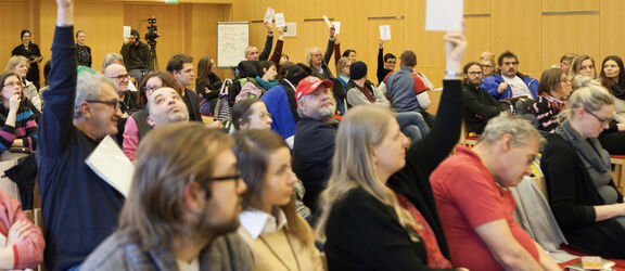 Teilnehmer:innen eines Workshops im Rahmen von Wiener Wege - Einige heben die Hand