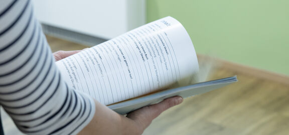 Mitarbeiterin mit dem Handbuch Gewaltprävention